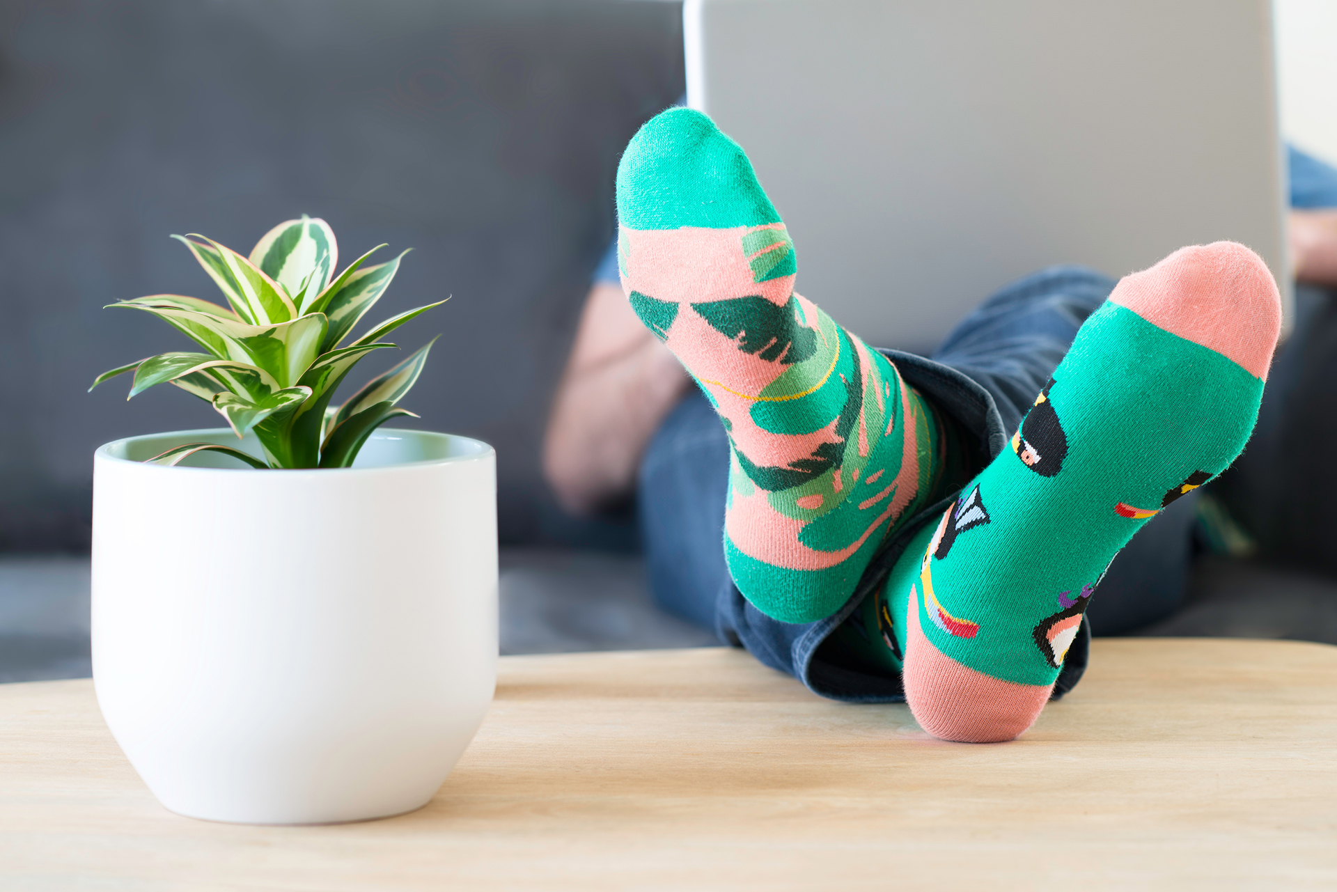 Auf dem Couchtisch sind zwei Füße mit bunten Socken abgelegt.