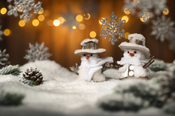 zwei kleine Schneemänner in winterlicher Landschaft