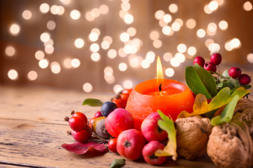 Eine weihnachtlich geschmückte Kerze brennt